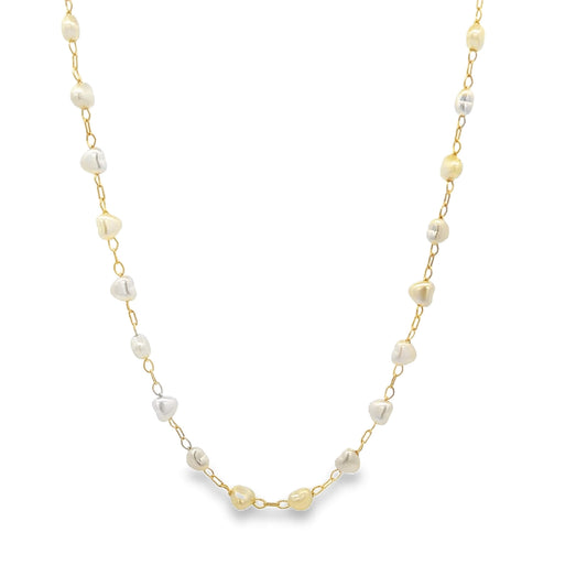 A delicate gold chain necklace drapes against a white background, featuring alternating white and yellow irregular pearl beads spaced evenly along its length.