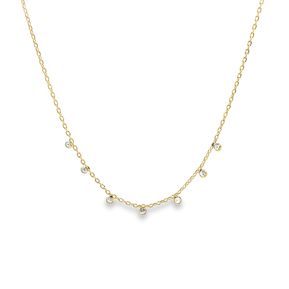 A delicate gold chain necklace sparkles with multiple bezel-set diamond station charms against a clean white background.