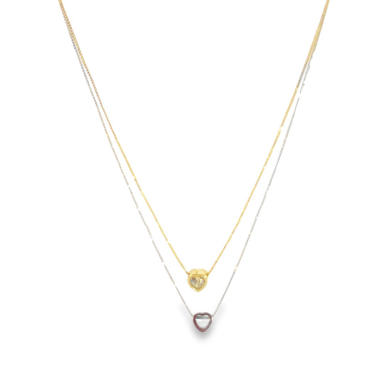 A delicate layered necklace features a gold heart pendant on the top chain and a silver heart pendant on the bottom chain.