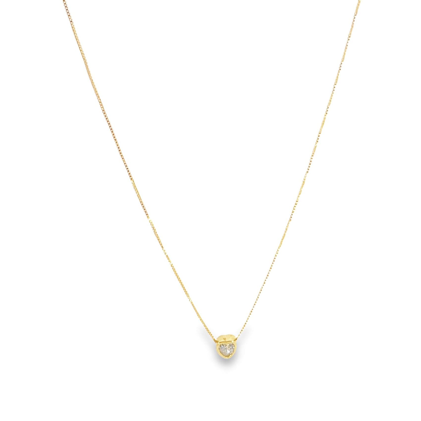 A delicate gold chain necklace hangs against a white background, featuring a small heart-shaped diamond pendant at its center.