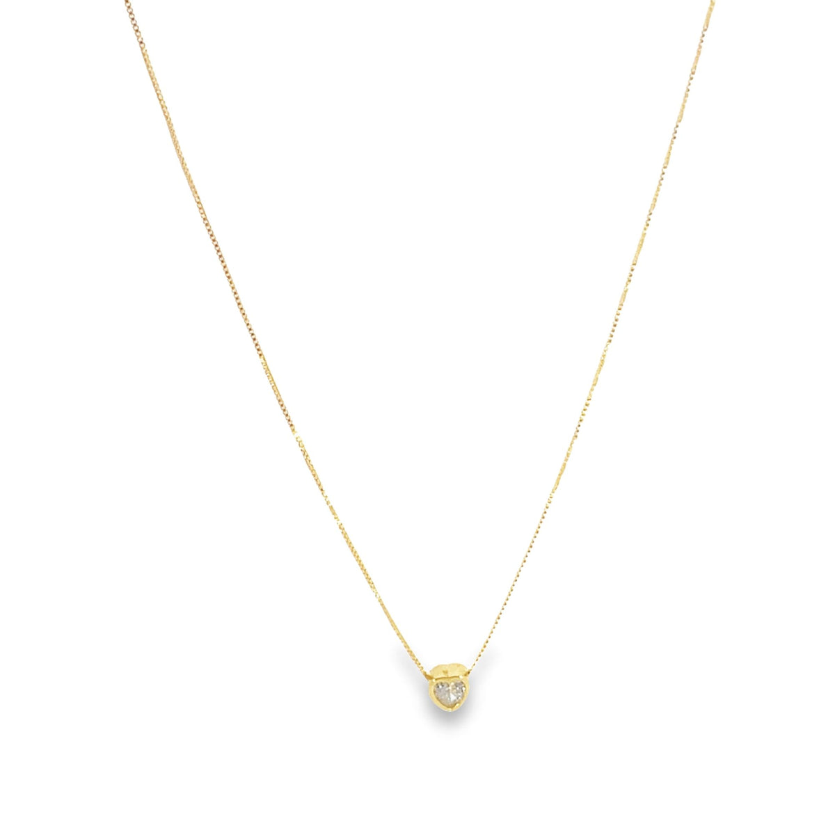 A delicate gold chain necklace hangs against a white background, featuring a small heart-shaped diamond pendant at its center.