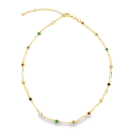 A delicate gold link necklace sparkles against a white background, featuring interspersed colorful gemstone stations.