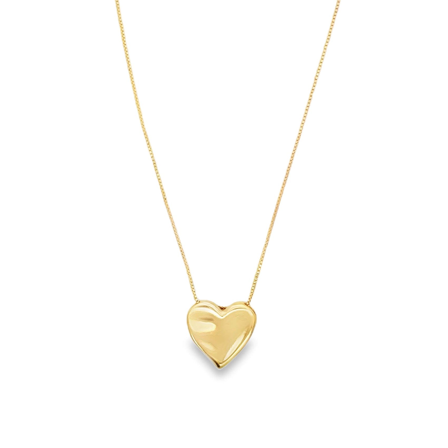 A gold heart pendant hangs delicately from a thin matching chain against a white background.