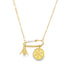 A delicate gold chain necklace features a safety pin pendant embellished with beads and charms, including a hand sign and a sun medallion.