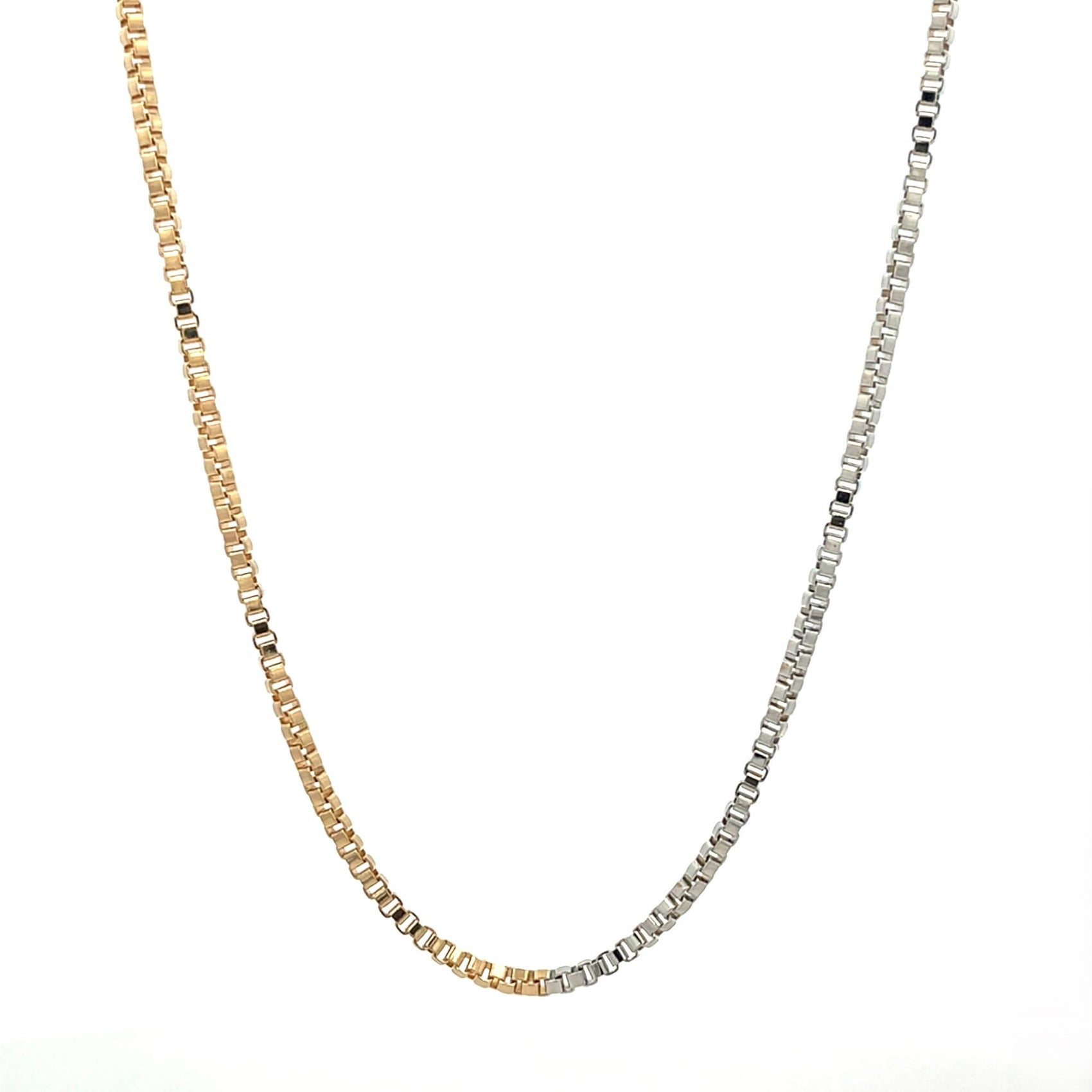 A sleek, two-tone box chain necklace gracefully drapes against a clean white background, showcasing a seamless transition from yellow gold to silver links.