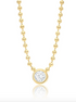 A gold beaded chain necklace showcases a round, bezel-set diamond pendant hanging in the center.