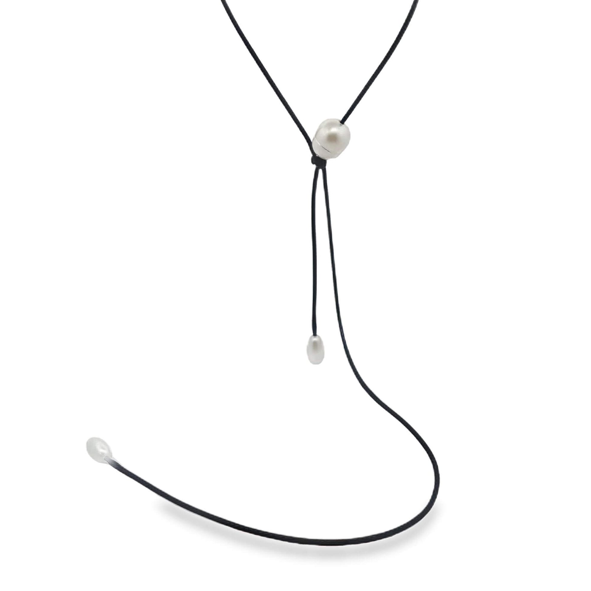 A delicate black cord necklace features three lustrous white pearls set against a clean white background.