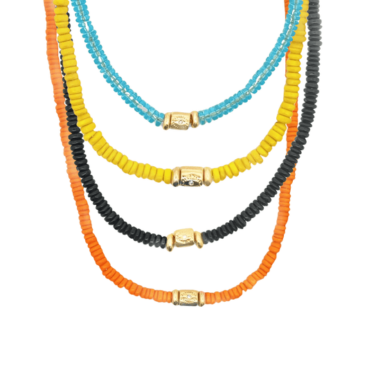 Four colorful beaded necklaces in blue, yellow, black, and orange feature central gold charms against a white background.