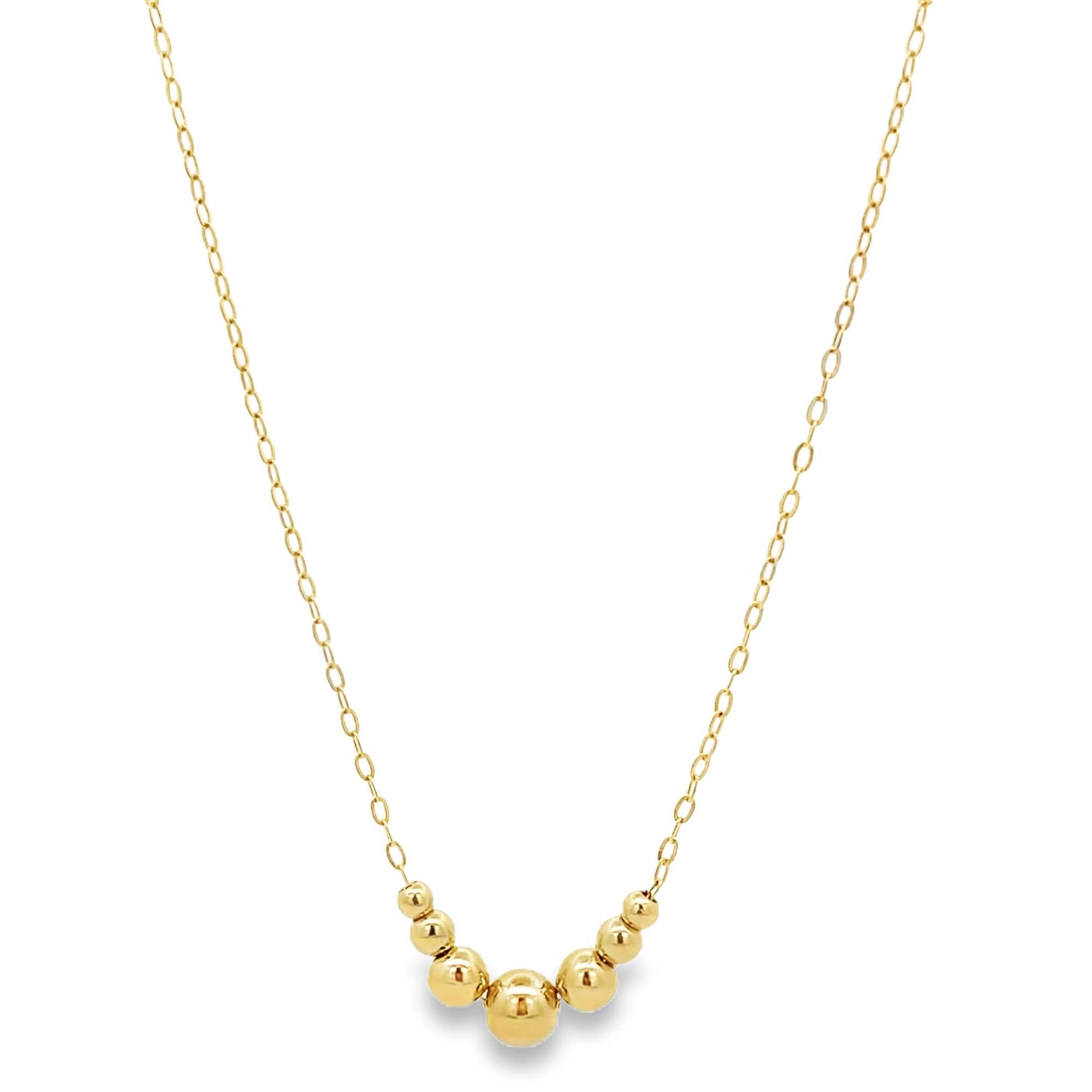 A delicate gold chain necklace features a cluster of polished gold beads suspended at the center.