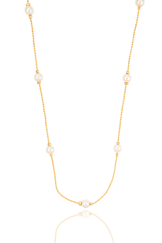 A delicate gold chain necklace with evenly spaced white pearls hangs against a clean white background.