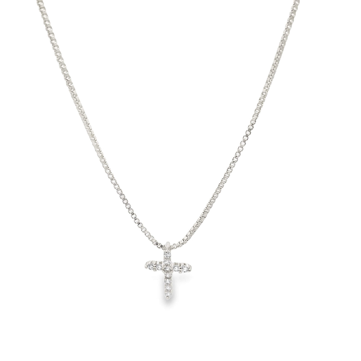 A delicate silver chain necklace features a sparkling diamond-encrusted cross pendant hanging against a plain white background.