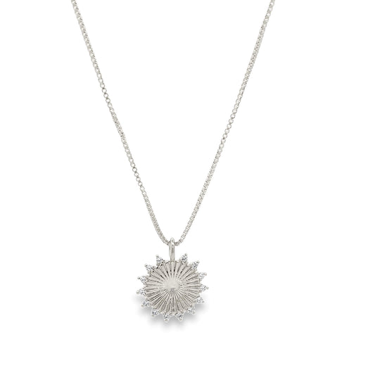 A delicate silver box chain necklace features a sparkling sunburst pendant embellished with tiny diamonds.