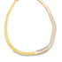 A gold herringbone chain necklace curves gracefully, featuring a sparkling row of baguette-cut zirconia stones along one side against a white background.