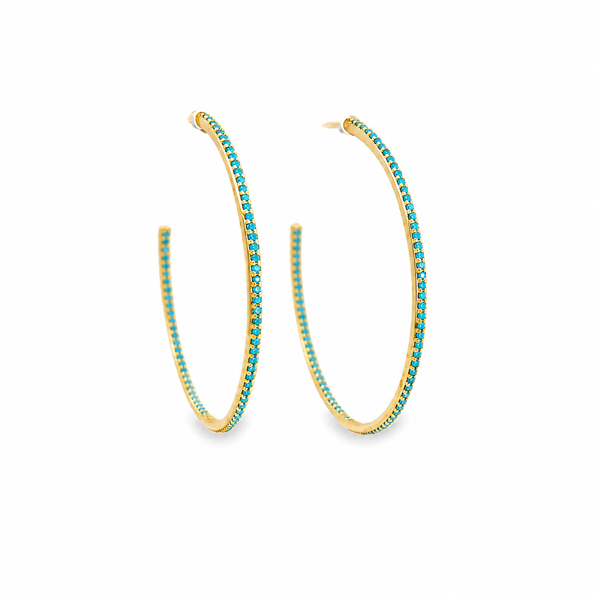 A pair of gold hoop earrings embellished with bright turquoise stones sits on a clean white background.