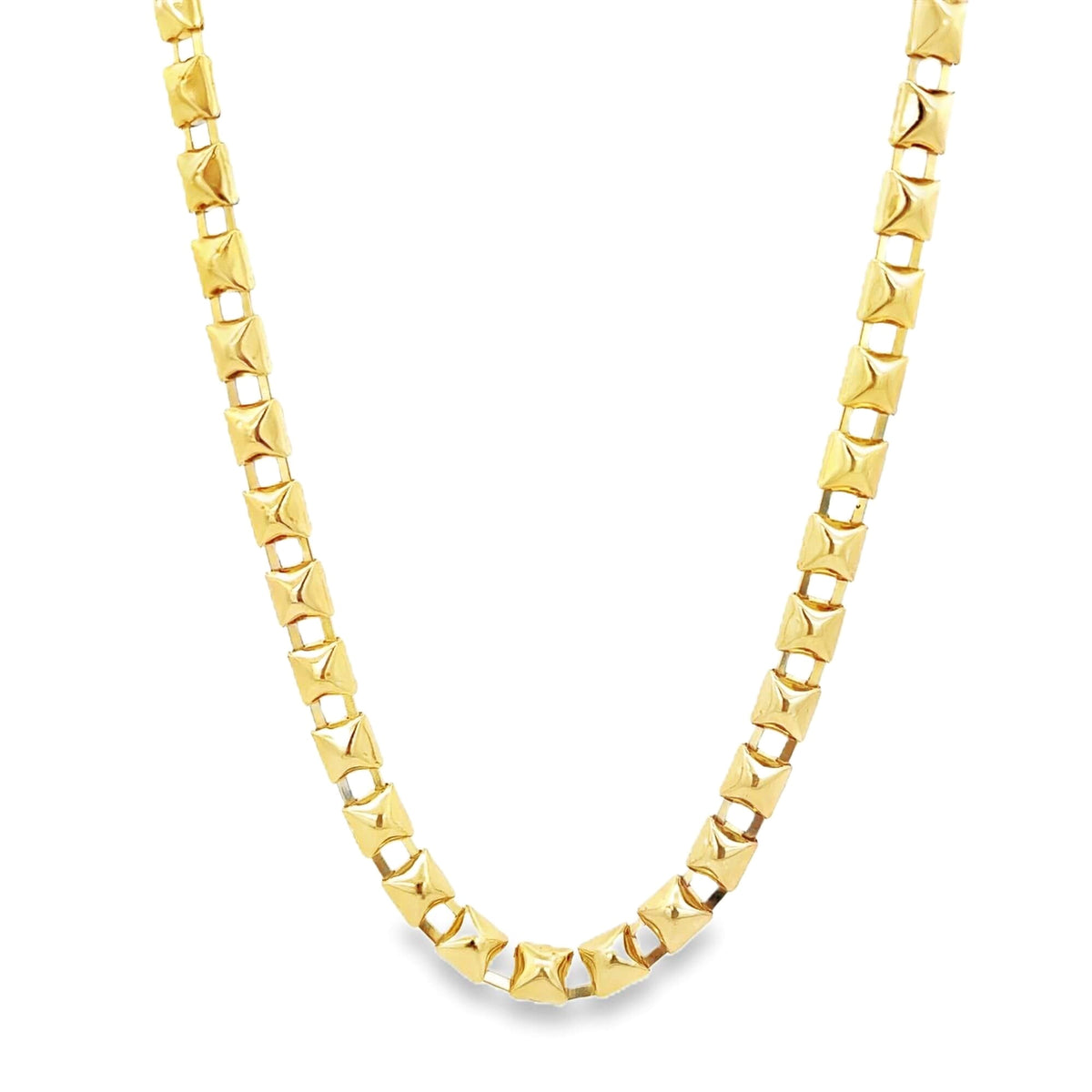 A shiny gold chain necklace features interlocking geometric square links against a clean white background.