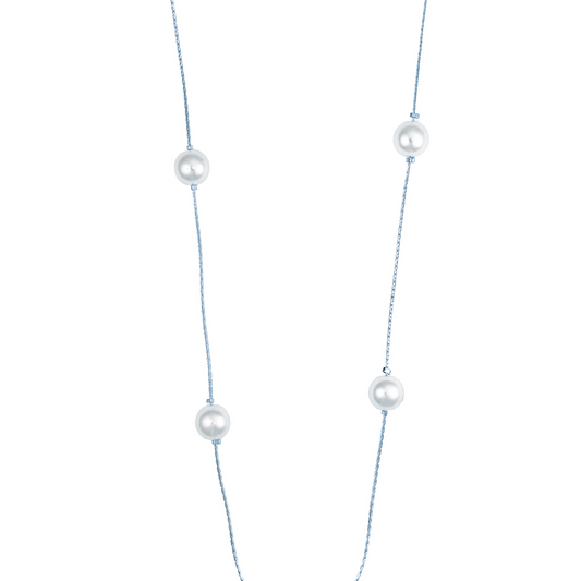 A delicate silver chain necklace features evenly spaced, luminous white pearls against a plain white background.