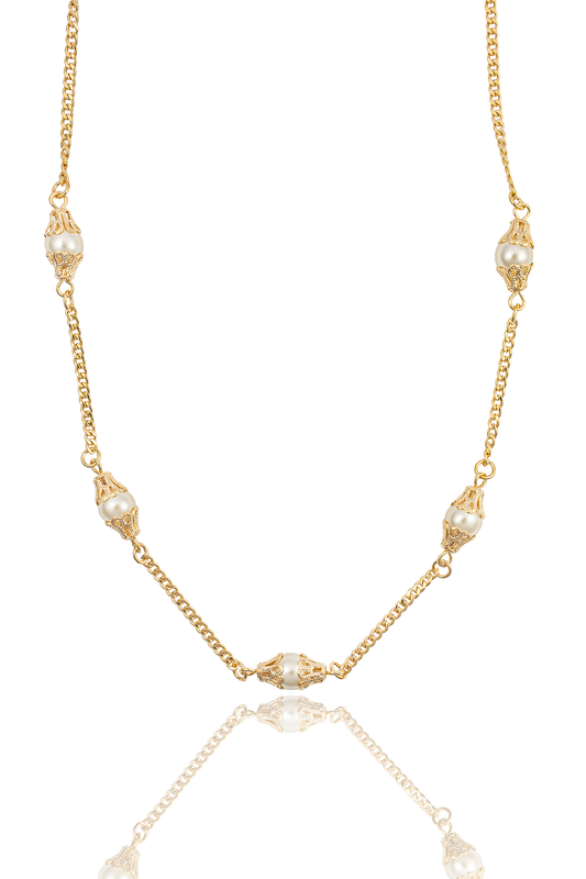 A delicate gold chain necklace features alternating white pearls encased in ornate filigree caps against a clean white background.