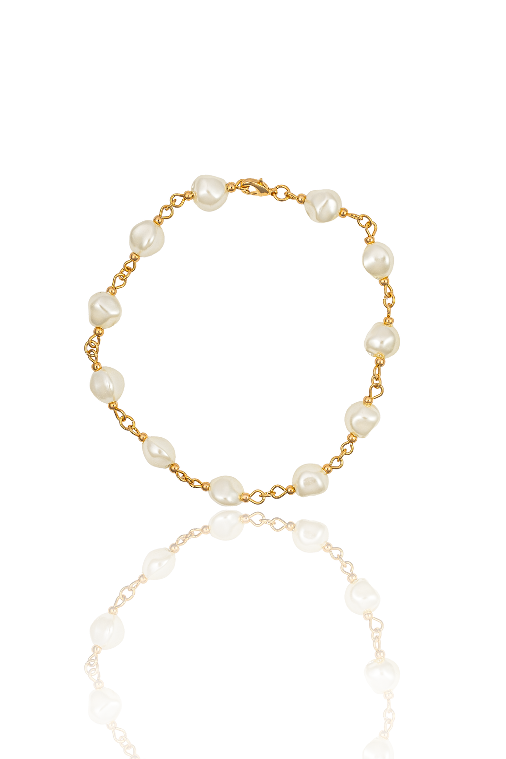 A delicate gold chain bracelet features baroque pearls and rests against a white background with a subtle reflection.