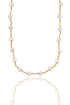 A delicate gold chain necklace featuring spaced freshwater pearls hangs against a clean white background with its reflection visible below.