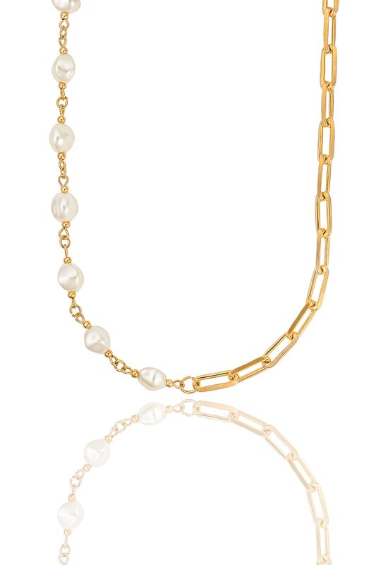 A gold-plated paperclip chain necklace features a section of baroque pearls on a white reflective surface.
