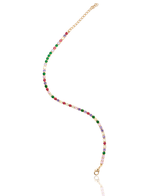 A gold tennis bracelet curves gracefully, showcasing a vibrant arrangement of multicolored cubic zirconia stones.
