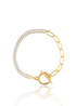 A gold paperclip link bracelet features a dazzling row of baguette-cut zirconia stones and a toggle clasp against a clean white background.