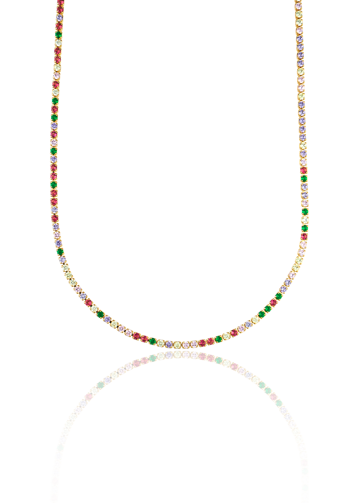 A gold tennis necklace featuring vibrant multicolored gemstones rests against a white background, casting a soft reflection below.