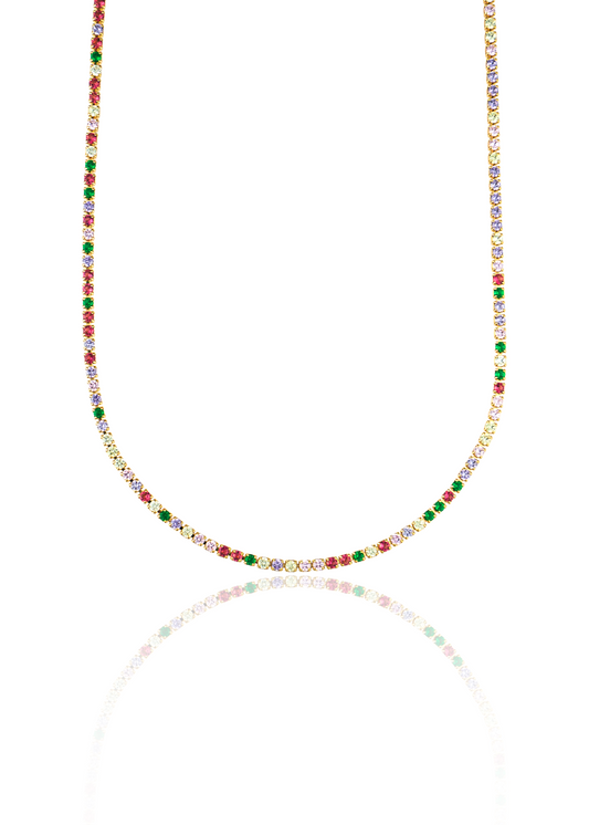 A vibrant tennis necklace sparkles with a continuous line of multicolored gemstone crystals set in gold against a crisp white background.