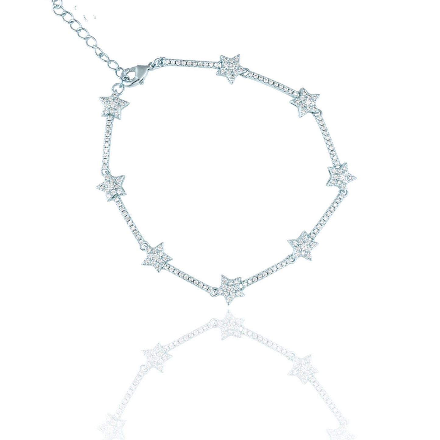 A sparkling silver star tennis bracelet with pavé-set rhinestones lies against a white background, casting a soft reflection below.