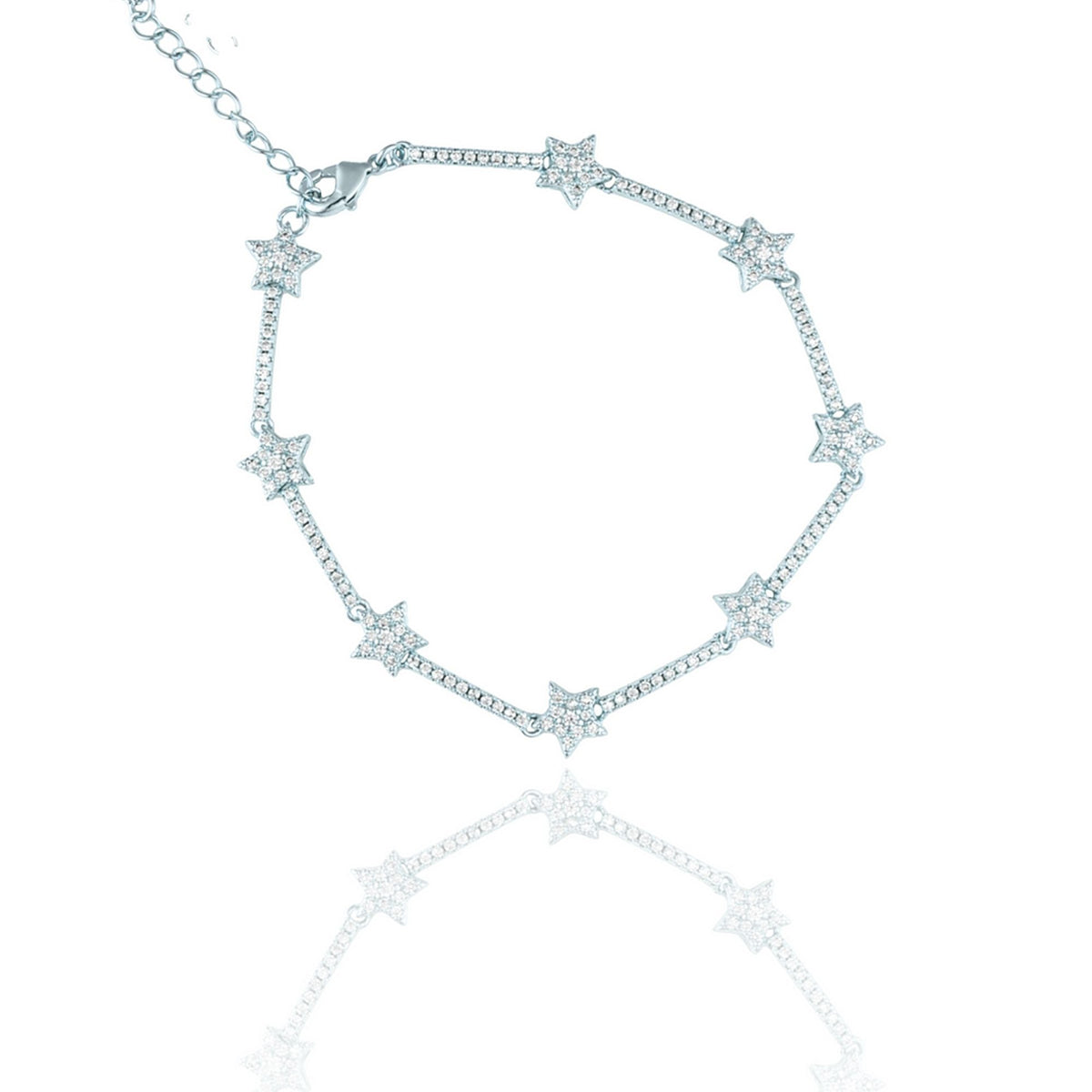 A sparkling silver star tennis bracelet with pavé-set rhinestones lies against a white background, casting a soft reflection below.