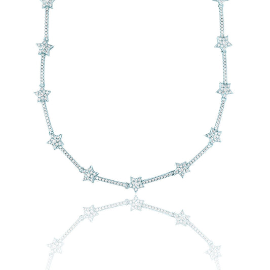 A delicate silver diamond star tennis necklace sparkles against a clean white background with its reflection below.