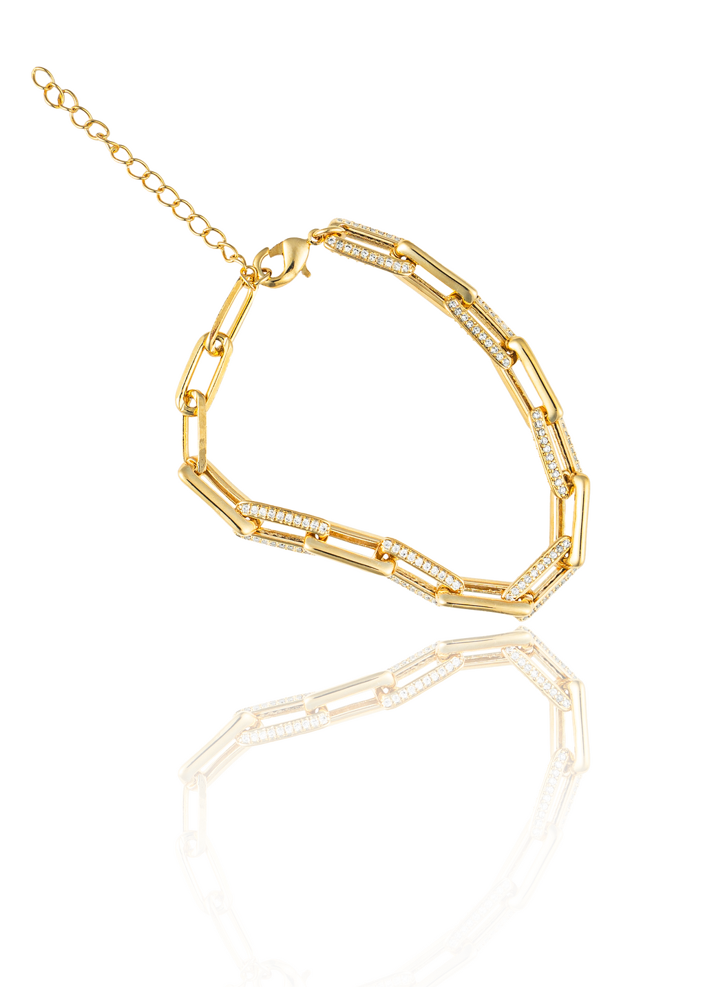 A gold link bracelet featuring interlocking paperclip charms encrusted with sparkling pave diamonds lies on a reflective white surface.