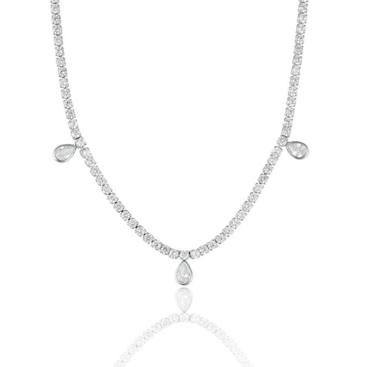 A sparkling diamond tennis necklace features three hanging pear-shaped stones against a clean white background.
