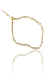 A gold tennis bracelet embedded with sparkling diamonds rests against a clean white background with its reflection below.