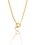 A delicate gold beaded necklace with a toggle clasp glimmers against a white reflective surface.