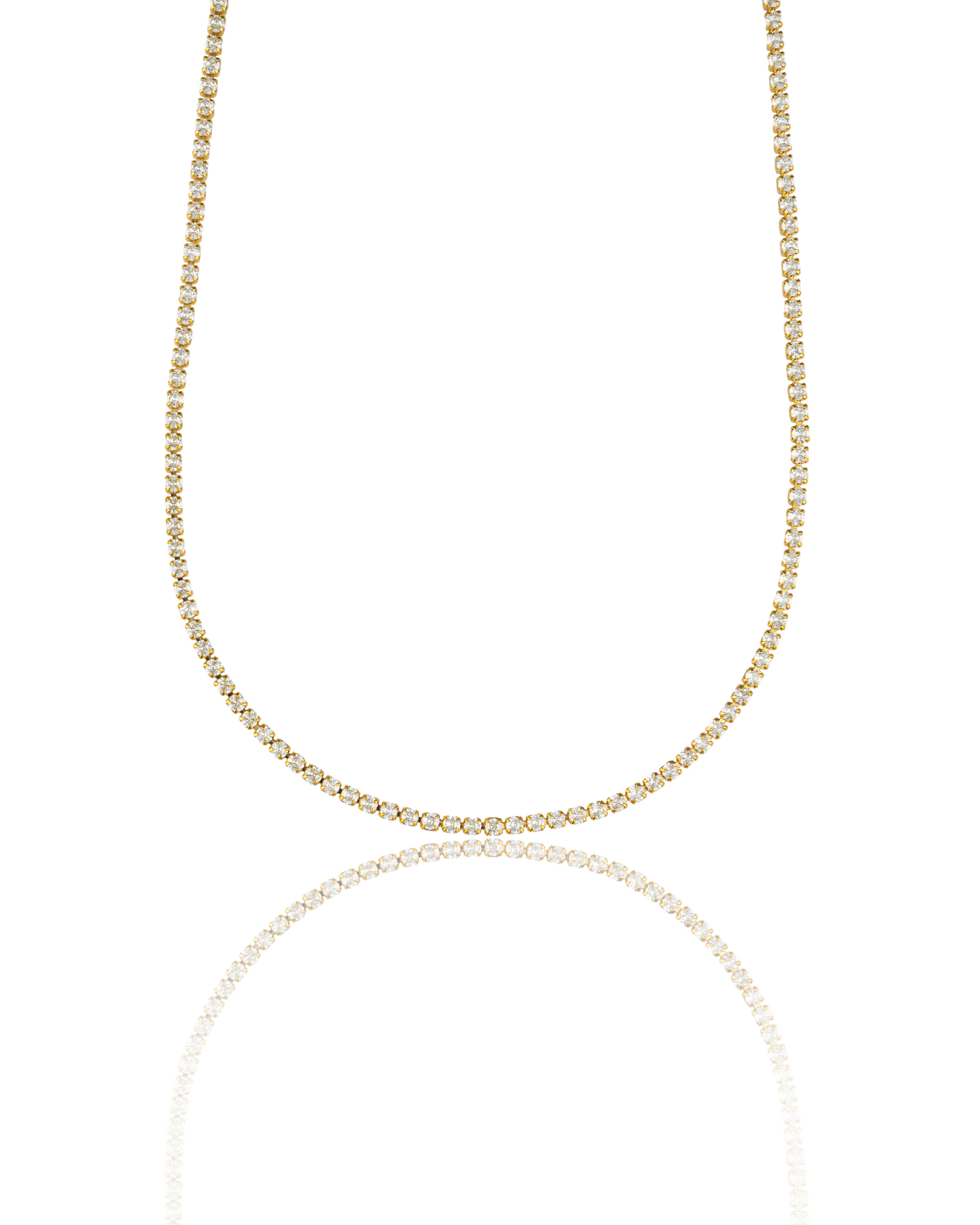 A glittering gold diamond tennis necklace sparkles against a clean white background, reflecting softly on a polished surface.