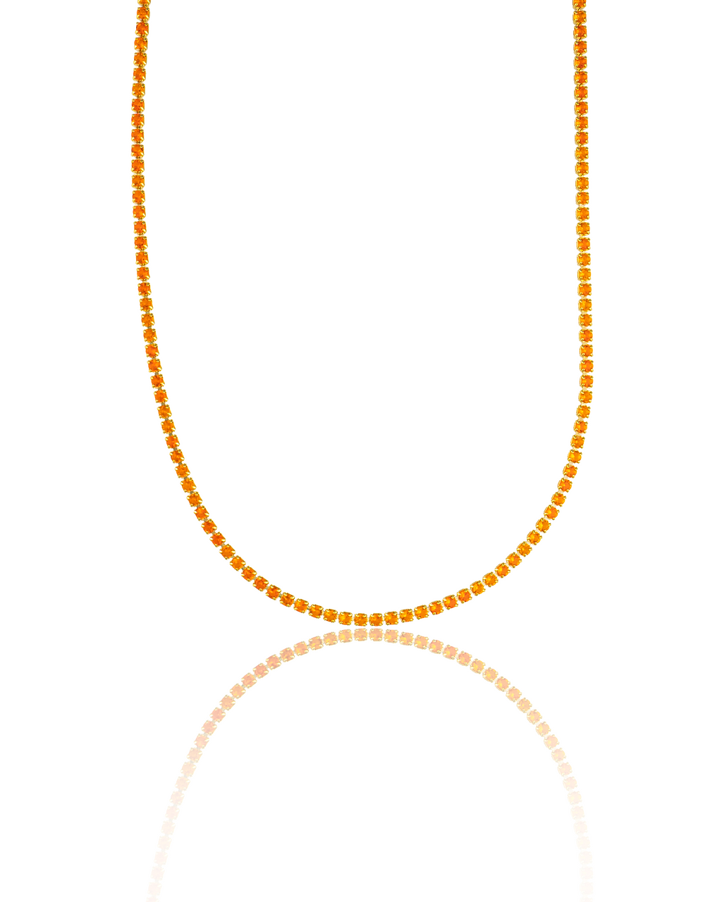 A sparkling orange crystal tennis necklace gleams against a white background with a glossy reflection below it.