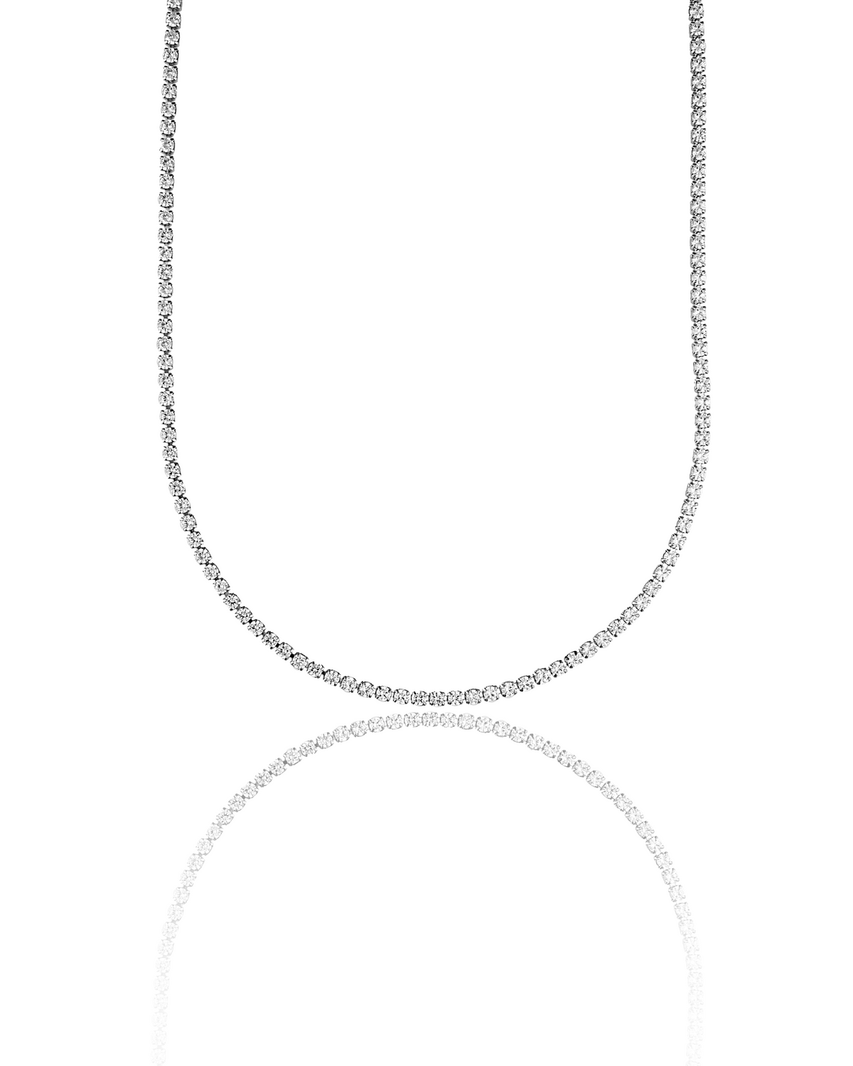 A sparkling diamond tennis necklace sparkles brightly against a clean white background, reflecting its brilliance on a mirrored surface below.