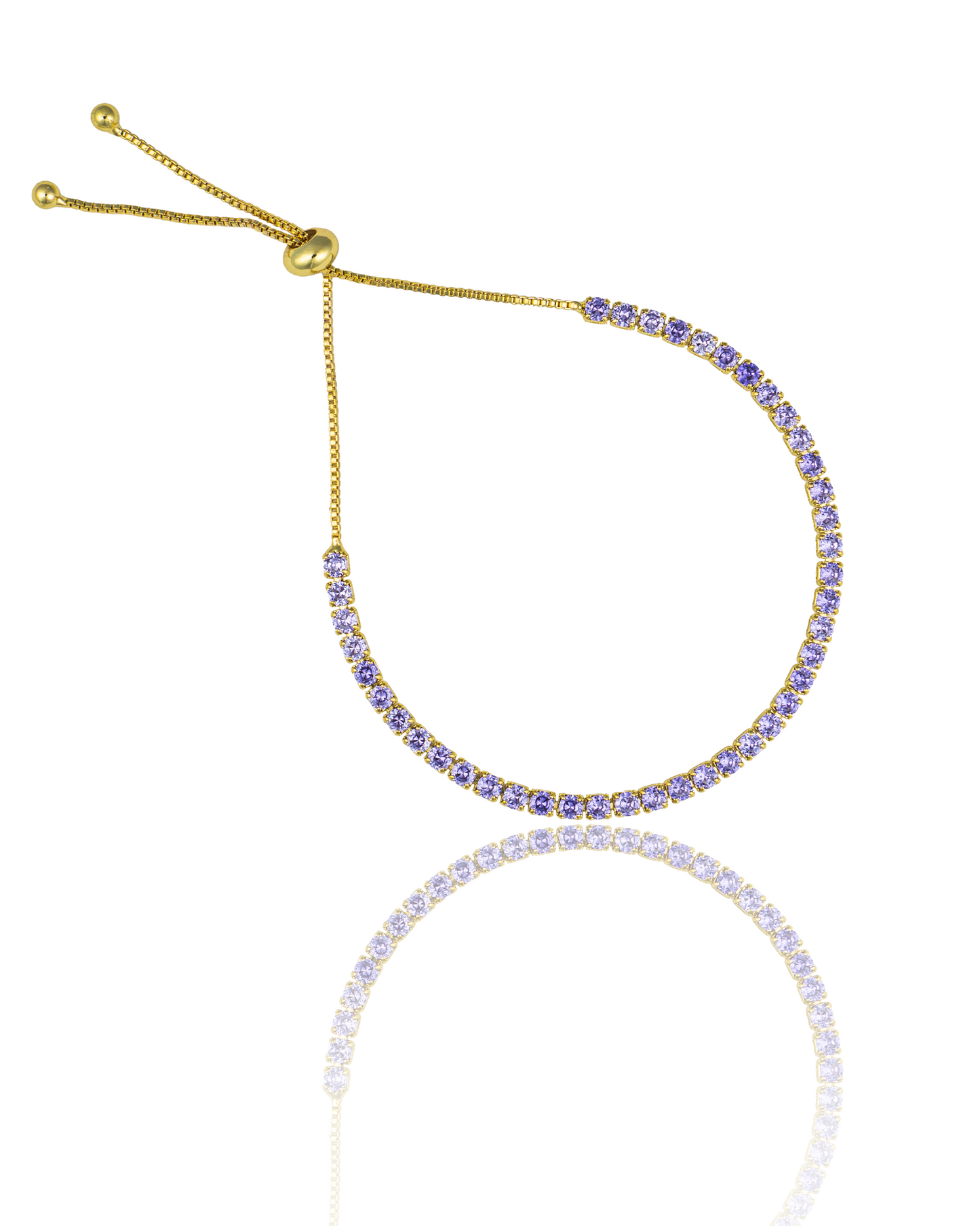 A gold adjustable tennis bracelet sparkles with a continuous line of vibrant purple cubic zirconia stones against a white background.