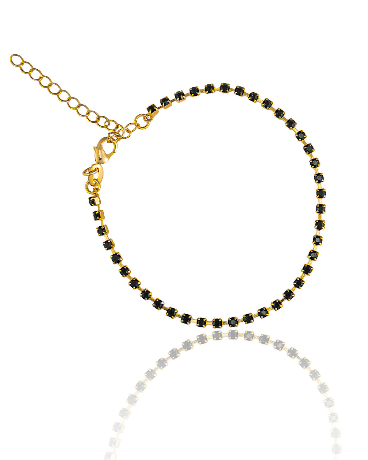 A delicate gold anklet features a continuous line of sparkling black rhinestones, a lobster clasp, and an adjustable extender chain against a white background.