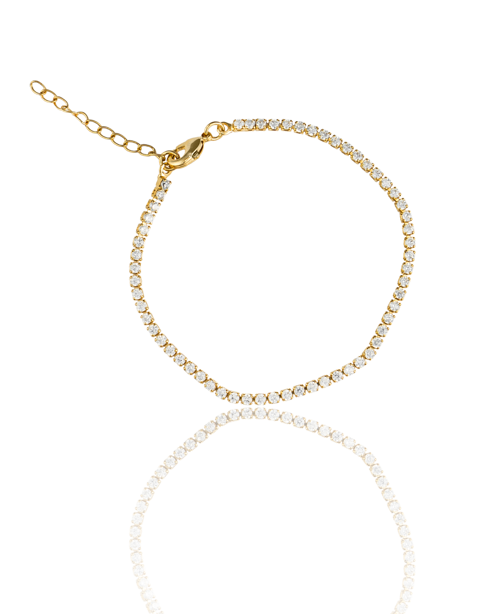 A sparkling gold tennis bracelet encrusted with diamonds rests against a clean white background with its reflection visible below.