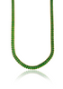 A gold tennis necklace featuring vibrant green emerald-cut gemstones drapes gracefully against a white background, casting a soft reflection below.