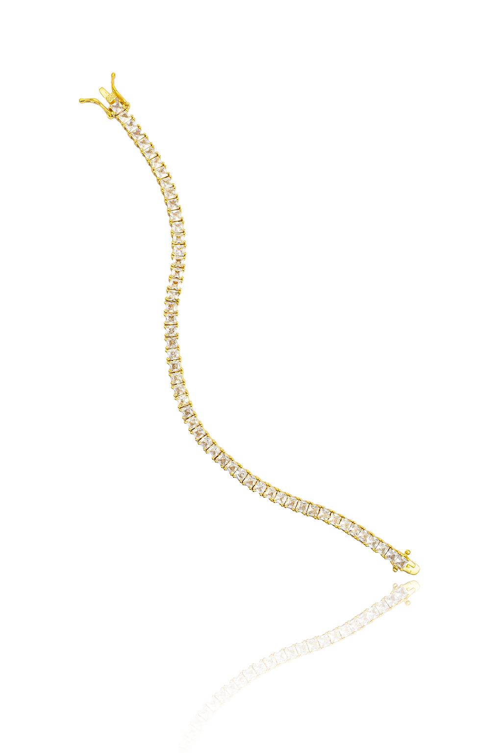 A delicate gold tennis bracelet sparkles with square-cut cubic zirconia stones on a white background.