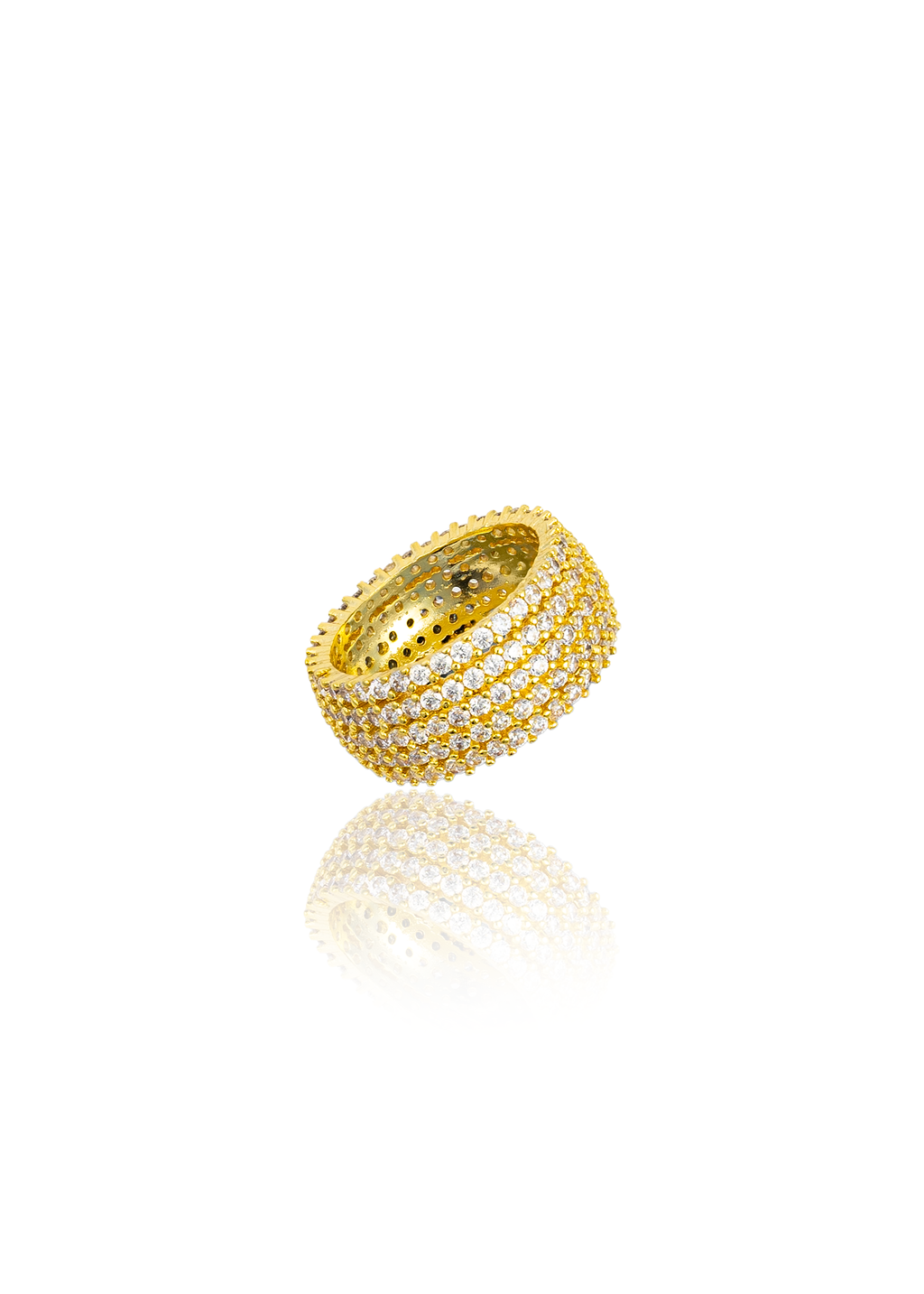 A thick gold pave ring encrusted with sparkling cubic zirconia stones sits against a white background, casting a soft reflection below.
