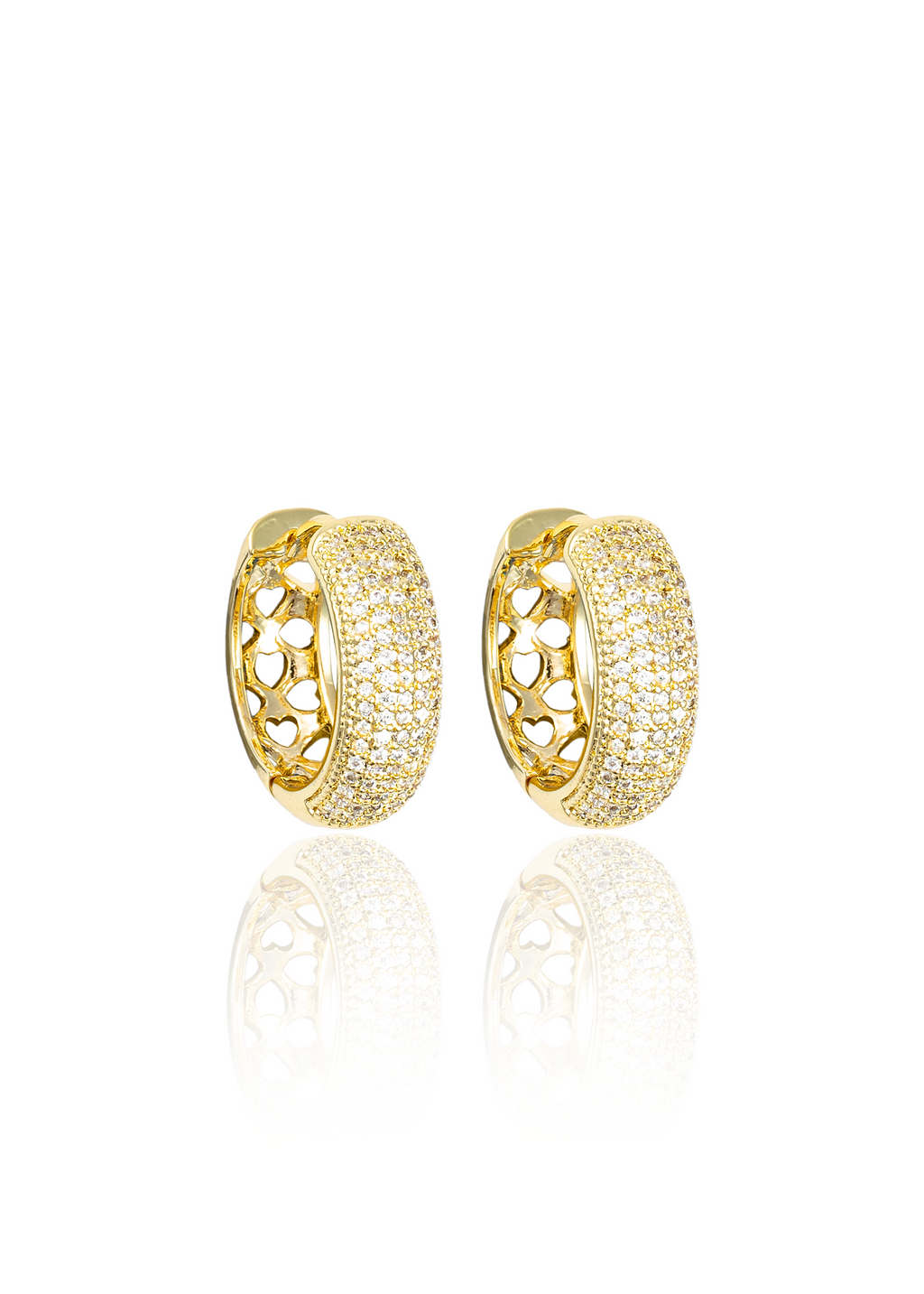 A pair of sparkling gold huggie hoop earrings featuring pavé-set crystals and intricate cut-out heart designs sits against a clean white background.