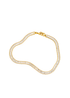A gold baguette-cut tennis bracelet with sparkling cubic zirconia stones rests in a curved shape against a white background.
