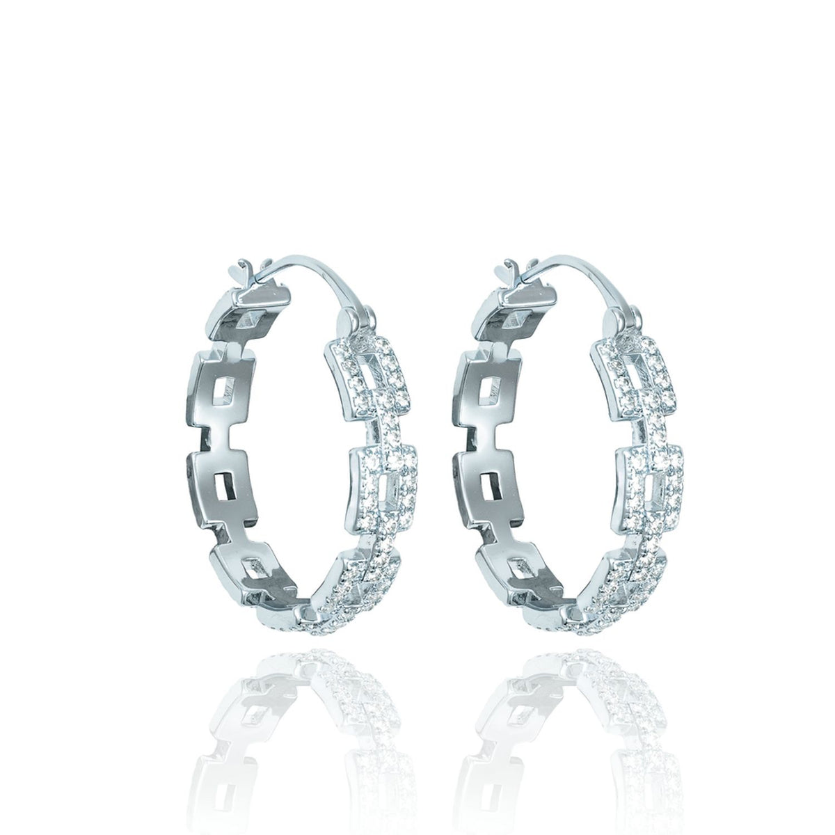 A pair of sterling silver hoop earrings with a geometric link design and sparkling pave stones rests against a white background.