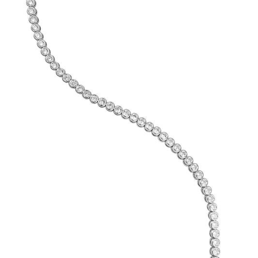 A delicate bezel-set diamond tennis necklace curves gracefully across a clean white background.