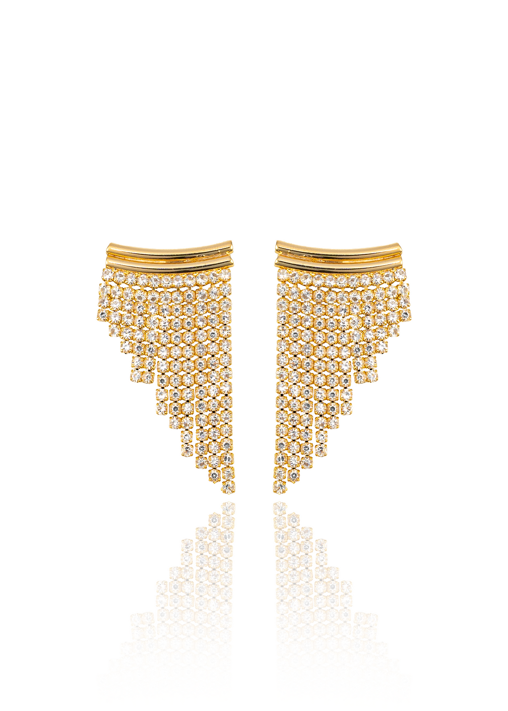 A pair of gold crystal tassel earrings sparkles against a clean white background, reflecting softly on the surface below.