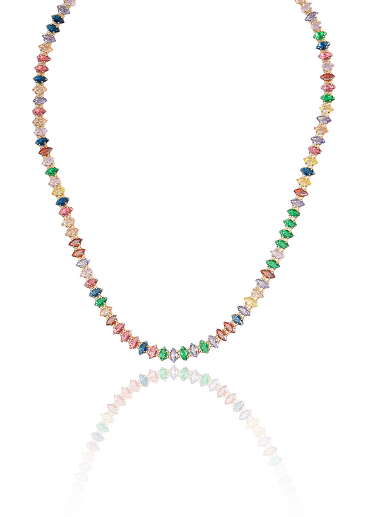 A vibrant gemstone tennis necklace sparkles against a clean white background with its reflection cast below.